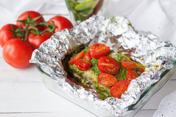 Preparation of salmon with pesto, tomatoes, asparagus