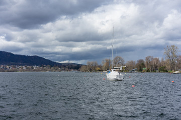 Fototapeta premium boat in harbour on lake zurich with clouds and blue water, zurich switzerland