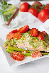 Salmon baked in foil with pesto, tomatoes, asparagus