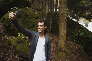 young man making selfie on the background of landscape