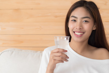 happy, smiling woman drinking fresh cold water; health related water intake, body hydration concept; young adult asian persian woman or asian middle east woman model