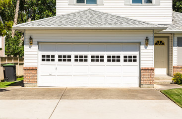 Wide garage door and concrete driveway in front of residential house