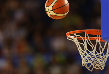 Fototapeta premium Basketball ball flies towards the basketball hoop on the background of the stands