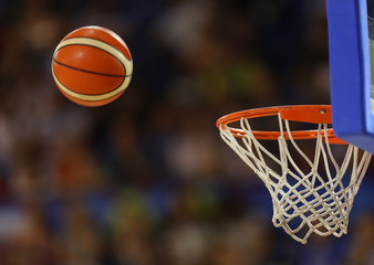 Naklejka premium Basketball ball flies towards the basketball hoop on the background of the stands