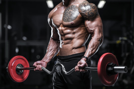 Handsome strong bodybuilder athletic men pumping up muscles with dumbbells