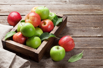 Green and red apples in wooden box