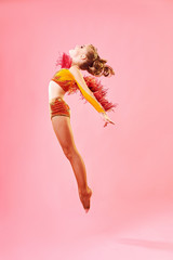 Contemporary dance. A little girl performs a complex acrobatic dance. Modern dance on a bright...