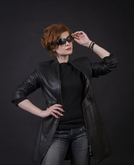 Emotional brunette posing in the Studio in a leather cloak.