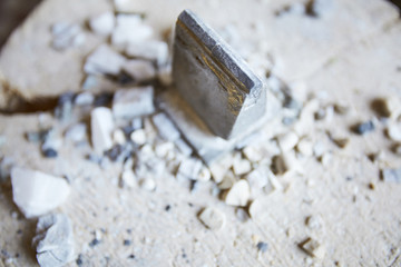 Close up shot of metal tool on concrete floor with stone shards scattered around, copy space
