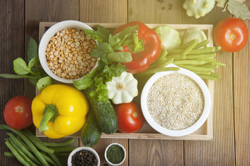 Health food with high fibre. Dietting, whole wheat cerals, grains, vegetables, antioxidants and vitamins: zzuchini, tomatoes, cucumbers, beans. Rustic wooden background top view.