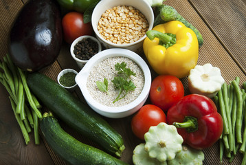 Health food with high fibre. Dieting, whole wheat cereals, grains, vegetables, antioxidants and vitamins: zzuchini, tomatoes, cucumbers, beans. Rustic wooden background top view.
