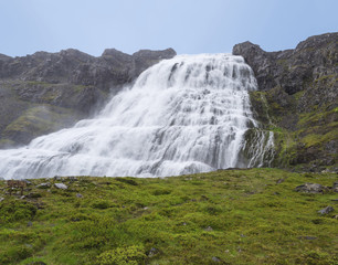 Fototapeta na wymiar Dynjandi waterfall, biggest in west fjords of Iceland in summer, rock, green grass and blue sky background