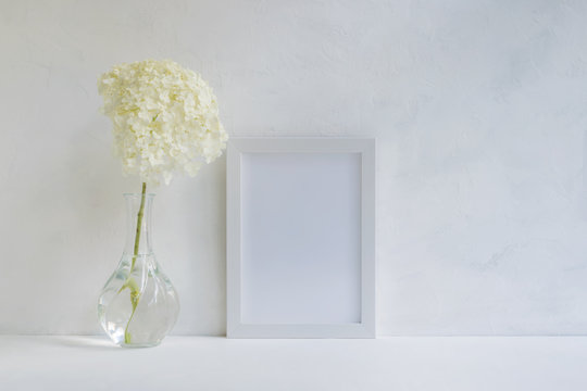 Mockup with a white frame and white flower hydrangea