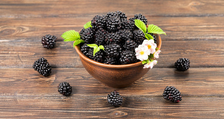 Blackberry in a clay plate. White background. Fresh berries.