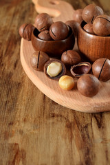 Obraz na płótnie Canvas Macadamia nuts on a wooden board