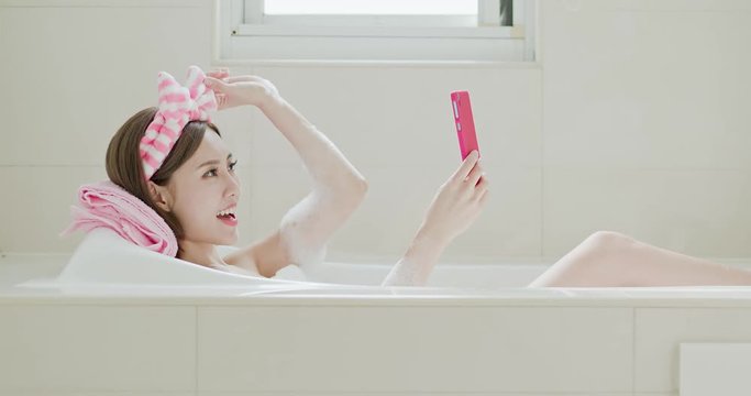womn selfie happily in bathtub