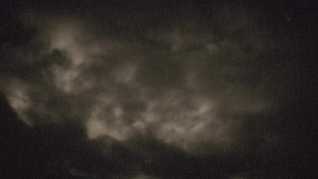 Eerie fast moving clouds, backlit by the low full moon - old film look or old projector look - ProRes