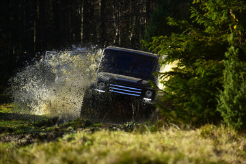 Rallying, competition and four wheel drive concept. Motor racing in autumn forest. Sport utility...
