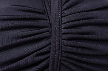 Black swimsuit bra push up seams of a string laces macro background