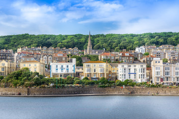 Sunny day in Weston-Super-Mare with the sea, town, church, trees and cloudy blue sky