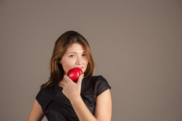 Girl in a black dress with a red apple