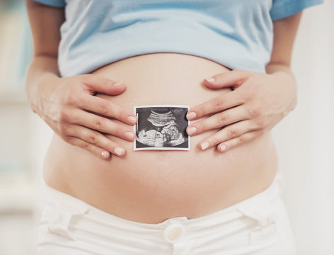 Pregnant Girl Holding Ultrasound Picture of Baby.