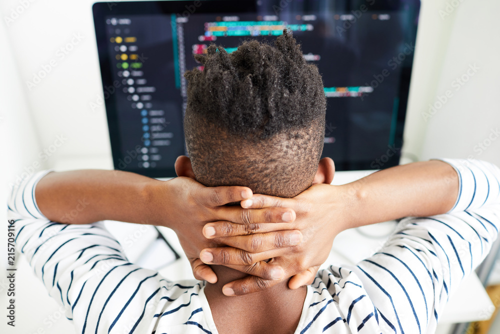 Sticker rear view of busy african-american male software engineer checking code on computer and holding hand