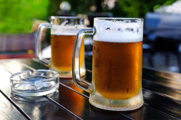 Beer in a glass glass glass, bubbles rise. On the background of green foliage glass with Golden drops.