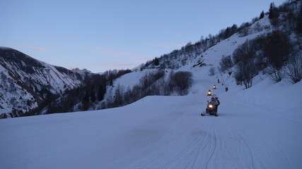 Fototapeta na wymiar Snowmobile during winter in the Alps during sunset