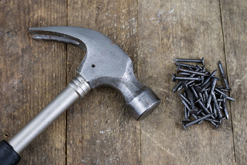 Hammer and nails on a wooden workshop table. Joinery accessories in a DIY workshop.