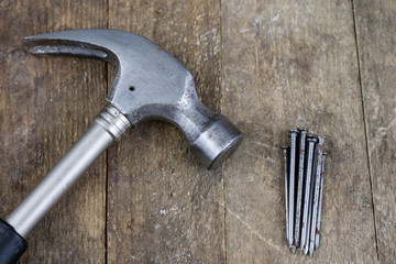Hammer and nails on a wooden workshop table. Joinery accessories in a DIY workshop.