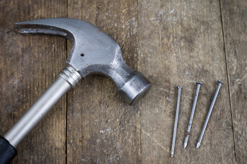 Hammer and nails on a wooden workshop table. Joinery accessories in a DIY workshop.