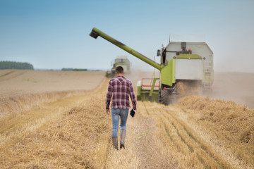 Farmer in front of combine harvester
