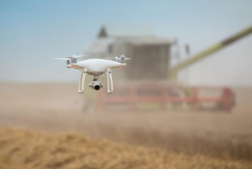 Drone flying in front of combine harvester