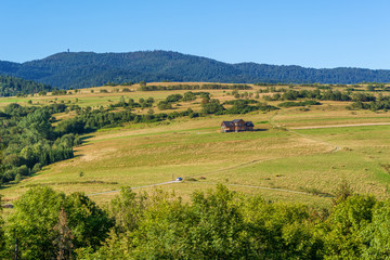 Fototapeta premium Picturesque rural landscape with house on fields in summer day. Pieniny mountains, Poland.
