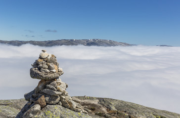 Norwegian stone pyramid with a cloud sea at background