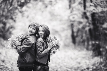 Fototapeta na wymiar Loving happy couple in autumn in park holding autumn maple leaves in hands.