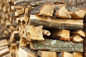 Firewood pile stacked chopped wood trunks for winter heating fireplace