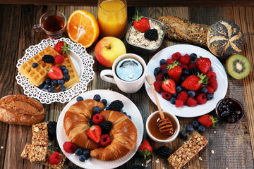 breakfast on table with waffles, croissants, coffe and juice.