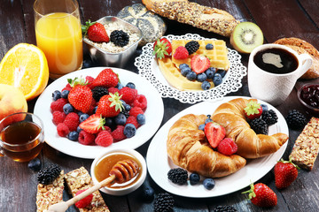 breakfast on table with waffles, croissants, coffe and juice.