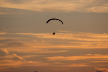 Gleitschirmflieger im gelben Abendlicht