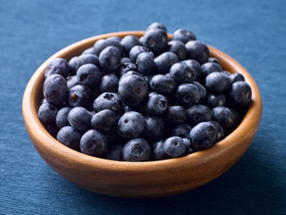 Closeup of fresh blueberries in a wooden plate
