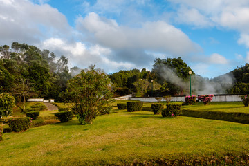 Picturesque park with evaporation from natural active geysers at side of Furnas town on Sao Miguel island of Azores, Portugal