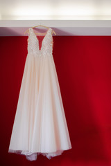 Cream wedding dress, lace and beads. Red background