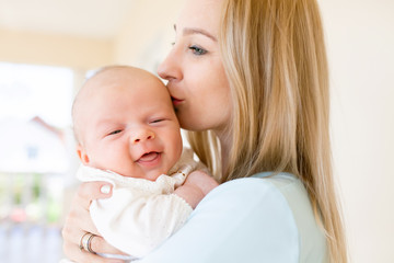 Mother holding a baby in her arms, family portrait.