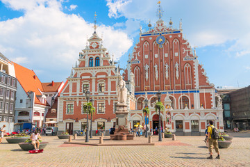 View of the Old Town square, Roland Statue, The Blackheads House near St Peters Cathedral against blue sky in Riga, Latvia. Summer sunny day - obrazy, fototapety, plakaty