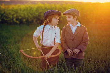 Portrait of children playing with bow and arrows, archery shoots a bow at the target