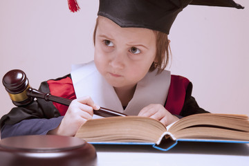 Portrait of serious child girl judge (lawyer) makes a decision. Humorous photo.