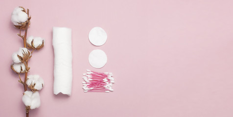 Fototapeta na wymiar Spa concept. Flat lay background with cotton branch, cotton pads, eared sticks. Cotton Cosmetic Makeup Removers Tampons. Hygienic sanitary swabs on the pink background Top view with space for text