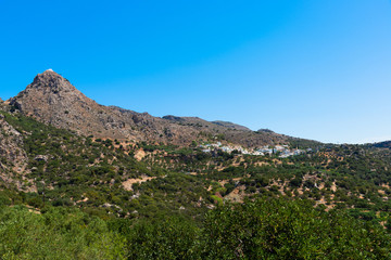 Fototapeta na wymiar Village on Lasithi Makrigialos mountains. Wonderland tour, steep slopes, rocky peaks for hiking adventure recreation sports in Crete, Greece.